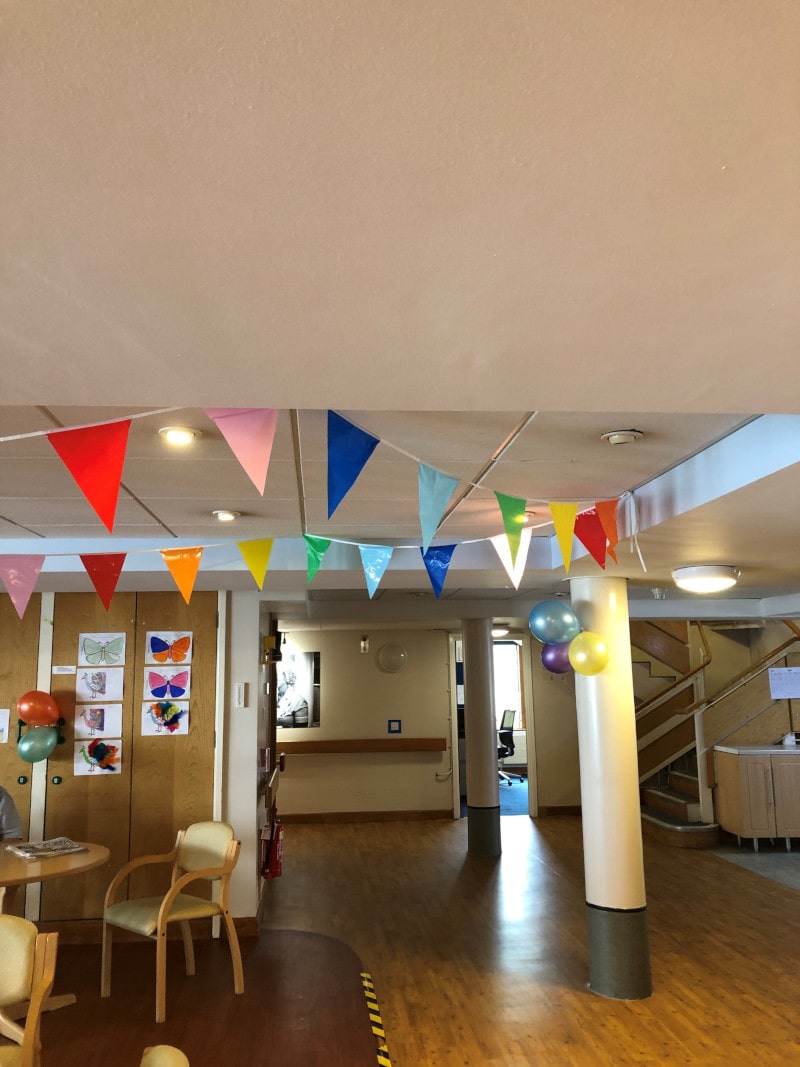 Decorating the lounge with rainbow bunting, balloons and laying the tables for lunch