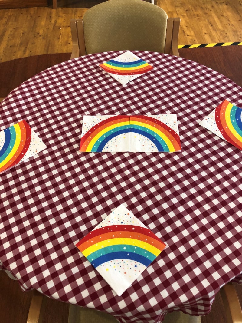 Decorating the lounge with rainbow bunting, balloons and laying the tables for lunch